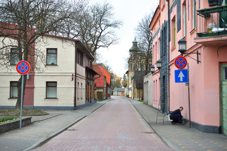 A man working on the empty street with an old traditional houses. No people because of coronavirus...