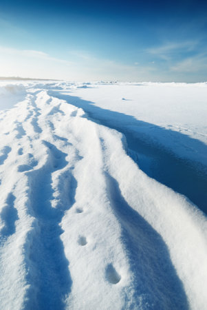 Ice pressure ridge on a frozen sea shore on a clear day, texture close-up. Picturesque winter scenery. Concept image. Seasons, nature, ecology, environment, climate change, global warmingの写真素材