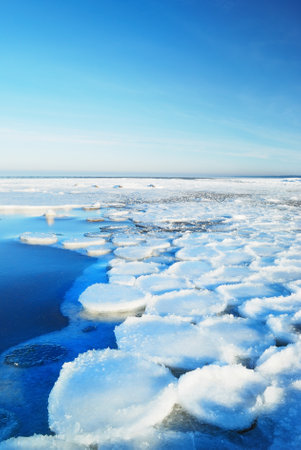 Ice pressure ridge on a frozen sea shore on a clear day, texture close-up. Picturesque winter...