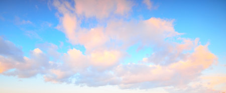 Clear blue sky with glowing pink cumulus clouds after a blizzard at sunset. Dramatic winter...