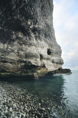 Picturesque panoramic low angle view of the Etretat white cliffs. Dramatic sky, atmospheric landscape. Summer vacations in Normandy, France. Travel destination, national landmark, sightseeing, historyの写真素材