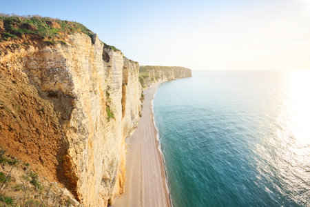 Picturesque panoramic aerial view of the Etretat white cliffs at sunset. Dramatic sky, azure water. Summer vacations in Normandy, France. Travel destinations, national landmark, sightseeing, historyの写真素材