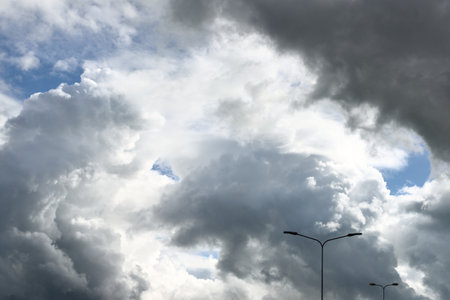 Street lantern against cloudy blue sky with cumulus clouds after the rain, close-up. Concept image....