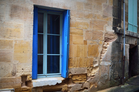 Exterior of the old traditional building. Northern France, Europe. Close-up of wall, blue window, decorative elements. Travel destinations, sightseeing, architecture, construction industry, historyの写真素材