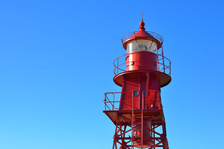 Red lighthouse against clear blue sky, close-up. Denmark, Europe. Travel destinations, landmark,...