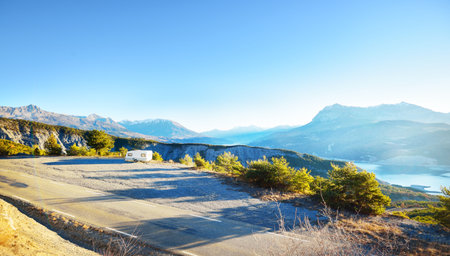 Caravan trailer stucked near the border of Italy because of travel ban, close-up. Coronavirus (COVID-19) outbreak, quarantine zone in France. An empty highway in a French Alps mountains on a clear dayの写真素材
