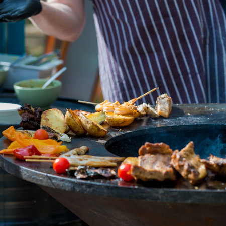 Man is cooking a grilled meat, fish and vegetables, close-up. Charcoal grill. Latviaの写真素材