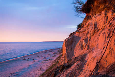 Stunning sunset clouds above the Baltic sea coast, Latvia. Cliffs close-up. Golden evening sunlight. Summer landscapeの写真素材