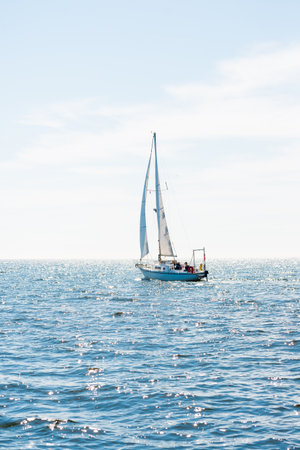 White sloop rigged yacht sailing in a Mediterranean sea on a clear sunny day, Spain. Blue sky with...