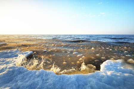 Frozen Baltic sea shore on a clear day, snow texture close-up. Blue sky. Picturesque winter scenery....
