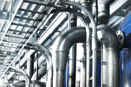Large industrial water treatment and boiler room. Shiny steel metal pipes, pumps, valves. Industry,...