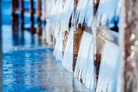 Snow-covered old rusty pier on a clear sunny day. Ice fragments close-up. Baltic Sea, Latviaの写真素材