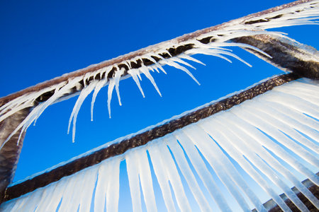 Snow-covered old rusty pier on a clear sunny day. Ice fragments close-up. Baltic Sea, Latvia