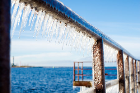 Snow-covered old rusty pier on a clear sunny day. Ice fragments close-up. Baltic Sea, Latviaの写真素材