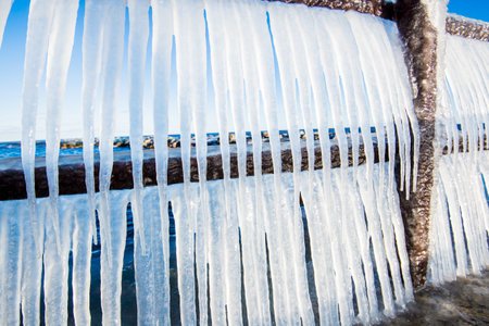 Snow-covered old rusty pier on a clear sunny day. Ice fragments close-up. Baltic Sea, Latviaの写真素材