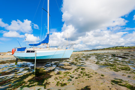 Yachts and boats during ocean low tide, close-up. Plouguerneau, Brittany, France. Clear sunny summer...