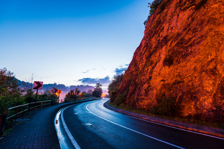 A view of a small town Dinant, Belgium, at night. En empty road through the parkの写真素材
