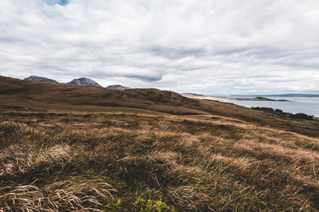 Panoramic aerial view of the shores, mountains and valleys of Jura island. Cloudy blue sky. Stormy weather. Paps of Jura, Inner Hebrides, Scotland, UK. Travel destinations, tourism, national landmarksの写真素材