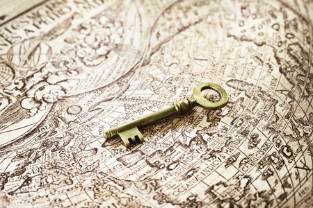 Retro styled golden antique key and old white nautical chart close-up. Vintage still life. Travel, navigation concepts, collecting, souvenir, gift, home, accessories, graphic resourceの写真素材