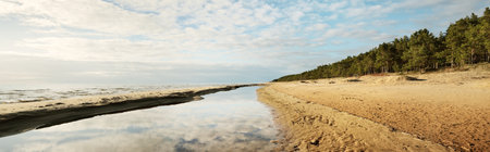 Baltic sea shore on a sunny day. Dramatic blue sky, lots of clouds, reflections on the water....