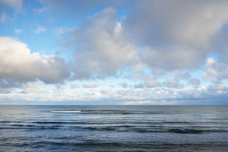 Panoramic view of the Baltic sea in winter. Clear blue sky with glowing cumulus clouds. Water...