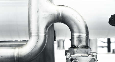Large industrial water treatment and boiler room. Shiny steel metal pipes and switches