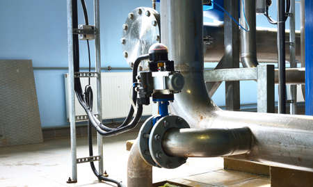 Large industrial water treatment and boiler room. Piping, bottom of a butterfly valve with servo