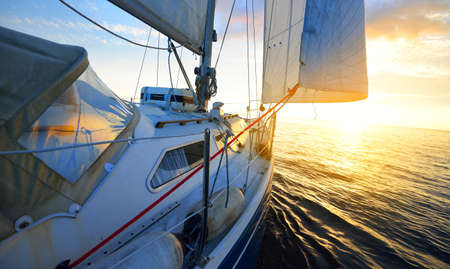 View from the deck of a yacht sailing in calm baltic sea at sunset. Clear sky with glowing golden...