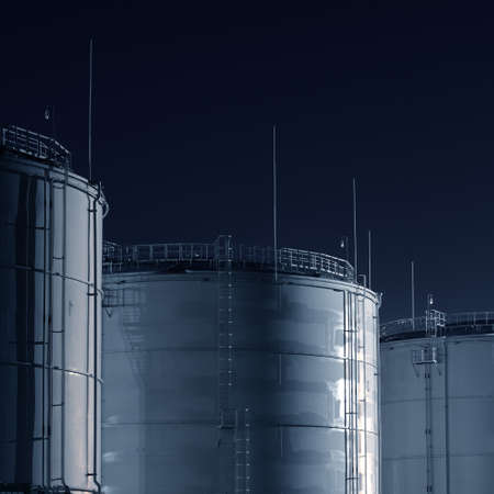 Fuel tanks in the cargo port terminal at night. Concept urban scene. Ecological issues, environmental damage, business, technology, commerceの写真素材