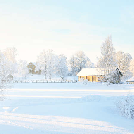 Winter landscape with cozy German style rural cottage in the countryside on a sunny day. Traditional architecture, travel destinations, Christmas vacations, ecotourism, remote placesの写真素材