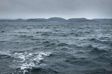 Glowing clouds above the sea. Waves, water splashes. Dramatic sky after the storm, epic seascape. A...
