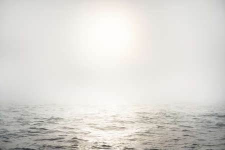 Baltic sea in a morning fog at sunrise, Sweden. View from a sailing boat. Soft golden sunlight, glowing clouds, golden hour. Picturesque panoramic scenery. Nature of Scandinaviaの写真素材