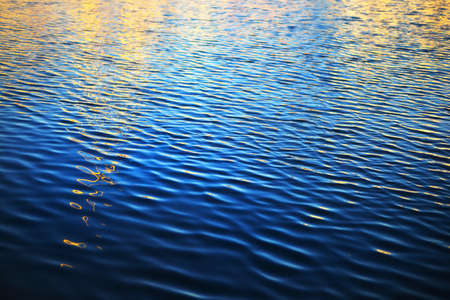 Water surface texture. Blue, azure, turquoise colors. Golden sunlight, sunrise. Abstract natural...