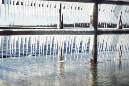 Frozen pier on the rocky shore of the Baltic sea. Clear blue sky. Concept winter landscape. Midday sun. Seasons, ecology, environment, climate change, global warming, anomaly. Panorama, copy spaceの写真素材