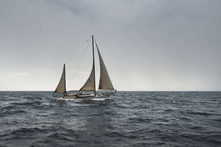 Old expensive vintage two-masted sailboat (yawl) close-up, sailing in an open sea during the storm....