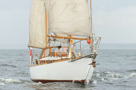 Old expensive vintage two-masted sailboat (yawl) close-up, sailing in an open sea during the storm....