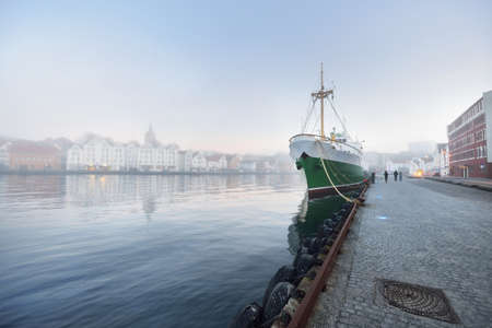 Green training ship moored to a pier in a city center. Stavanger embankment, Norway. Travel...