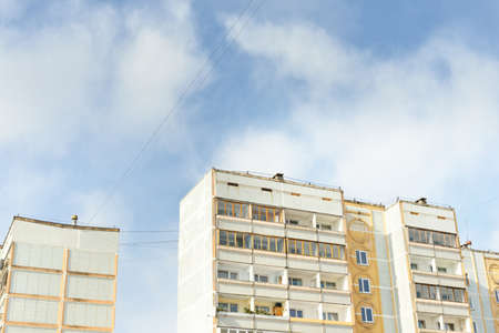 Soviet era block panel houses. Cloudy blue sky, dramatic cloudscape. Panoramic view. Real estate development, architecture, building exterior, construction industry, technology, history, pastの写真素材