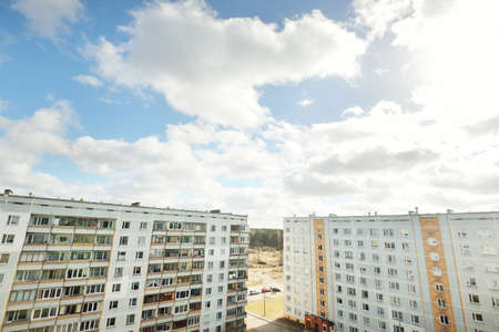Soviet era block panel houses. Cloudy blue sky, dramatic cloudscape. Panoramic view. Real estate...