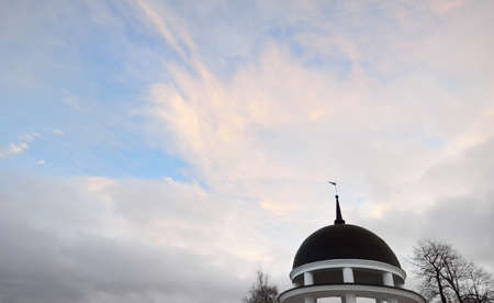 Gazebo roof and spire against clear sunset sky with glowing clouds. Architecture, nature,...