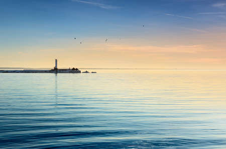 lighthouse in the sea at the colorful sunsetの写真素材