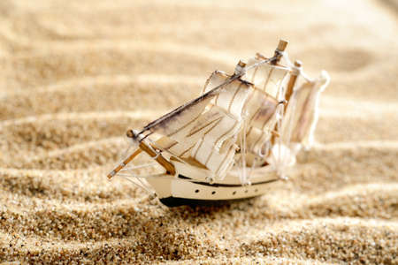 wooden sail ship toy model in the sea sand close-upの写真素材