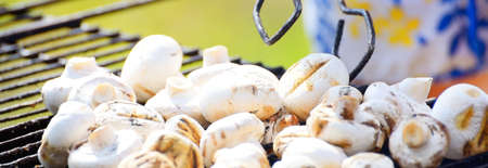 Charcoal grilled champignon mushrooms and smoke close-up. Culinary, healthy eating, lifestyle, organic, vegetarian, vegan food, cooking, summer vacations themeの写真素材