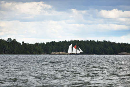 An elegant two-masted gaff schooner (training tall ship) sailing in MÃ¤laren lake, Sweden. Travel, history, traditions, transportation, sailing, sport, cruise, regatta, teamwork. Panoramic viewの写真素材