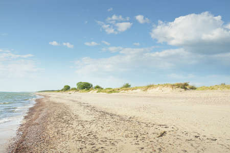 Baltic sea coast. Clear blue sky. Soft sunlight. Beach, sand dunes, pebbles. Pure nature,...