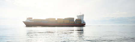 Large cargo container ship sailing in an open Baltic sea on a clear day. Freight transportation,...