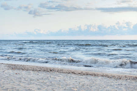 Baltic sea shore (sand dunes, beach) after the storm. Sunset, soft golden sunlight, glowing clouds....