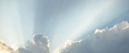 Epic storm cloudscape. White ornamental sunset cumulus clouds. Soft golden sunlight. Clear blue sky....