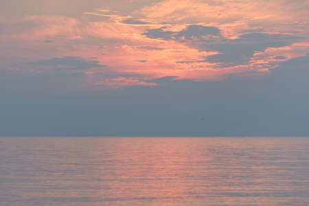 Baltic sea after the rain. Dramatic sunset sky, glowing pink and golden storm clouds. Picturesque...