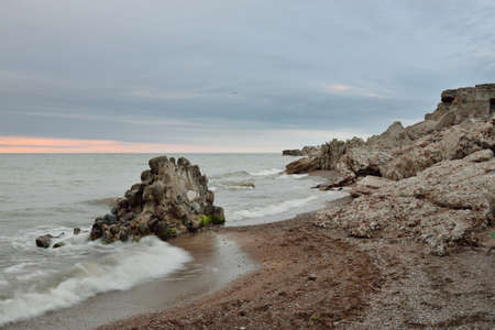 Panoramic view from the Baltic sea shore (beach) at sunset. Ruins and rocks. Picturesque scenery....